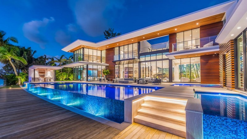 Miami Beach waterfront estate with infinity pool illuminated at twilight
